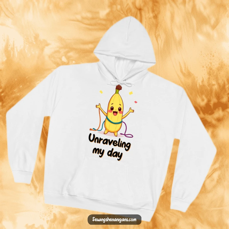 Funny Hoodie: A curious banana character joyfully juggling colorful threads, offering warmth and a delightful dose of playful energy.