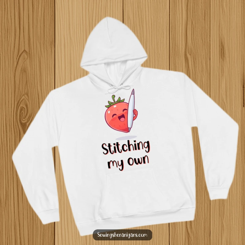 Funny Strawberry Needle Hoodie: An excited strawberry character gripping a large needle, perfect for a funny and warm gift.