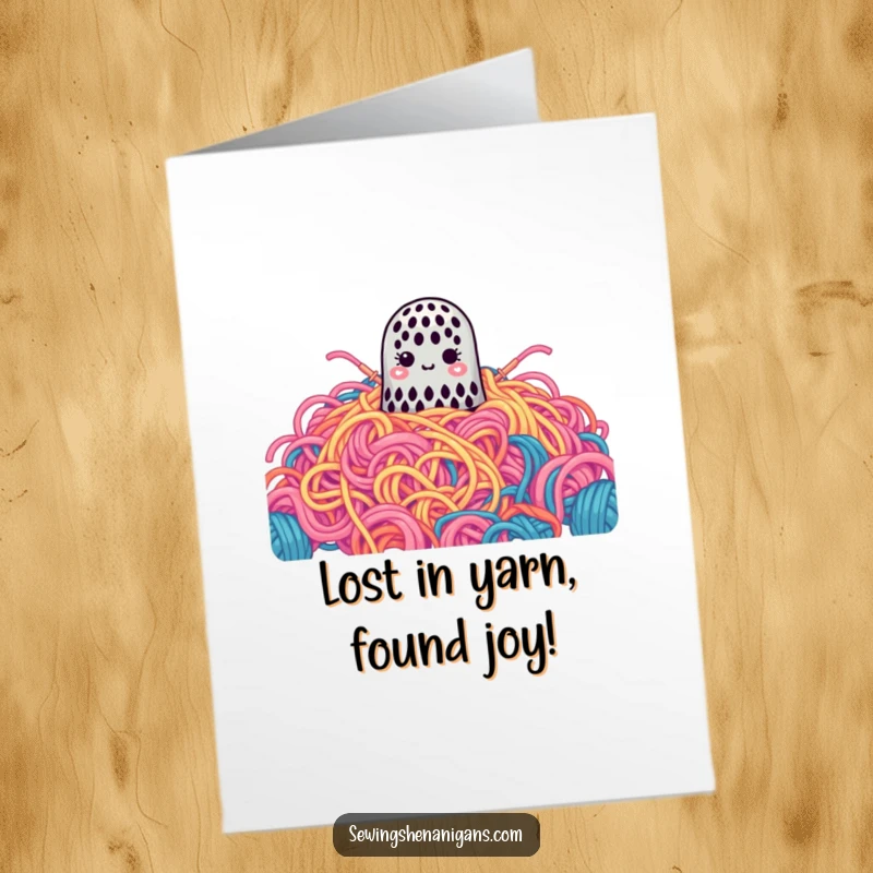 Funny Free Printable Birthday Card: A cute thimble appears lost in a massive, colorful pile of yarn, perfect for crafters.