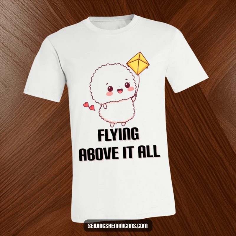 Funny T-Shirt: A happy pincushion uses a fluffy fabric scrap as a kite, a humorous and uplifting sewing image.