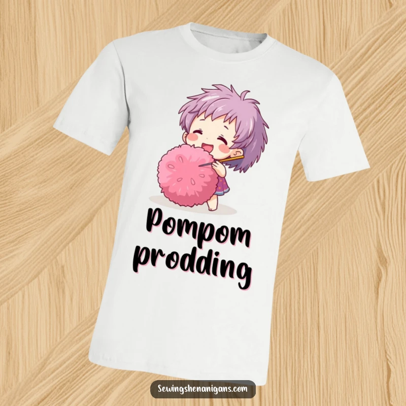 Funny t-shirt depicting a joyful character playfully using a needle to interact with a giant pom-pom, a whimsical design.